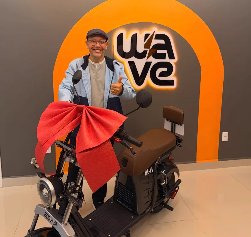 Cliente comemorando a entrega da sua HE-15 com laço vermelho na loja Wave